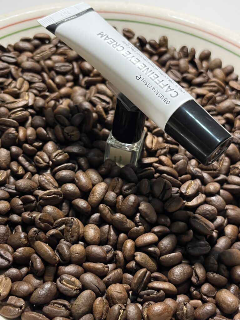 Behind the scenes of the production photo. The Inkey List eyecream is taped to a small perfume bottle that holds it above the bowl of coffee beans